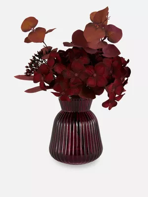 Arreglo floral artificial en jarrón de vidrio